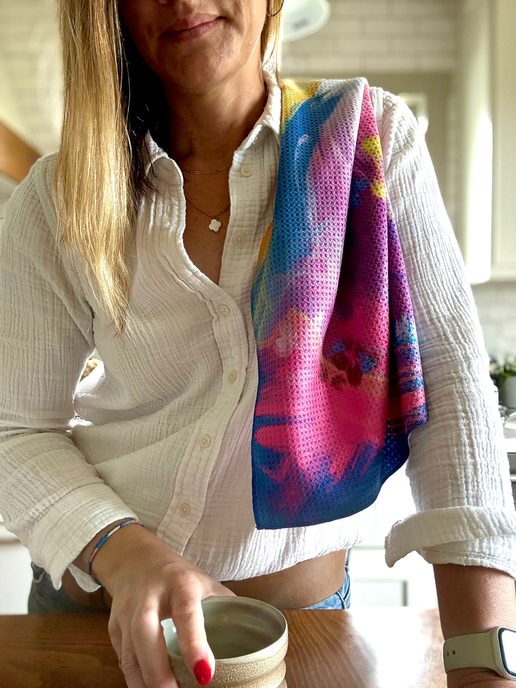 Colorful abstract floral quick-dry towel over a woman's shoulder in the kitchen. Bloom design is based on Isaiah 35:2.