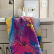Colorful abstract floral quick-dry towel hanging by laundry room sink. Bloom design is based on Isaiah 35:2.