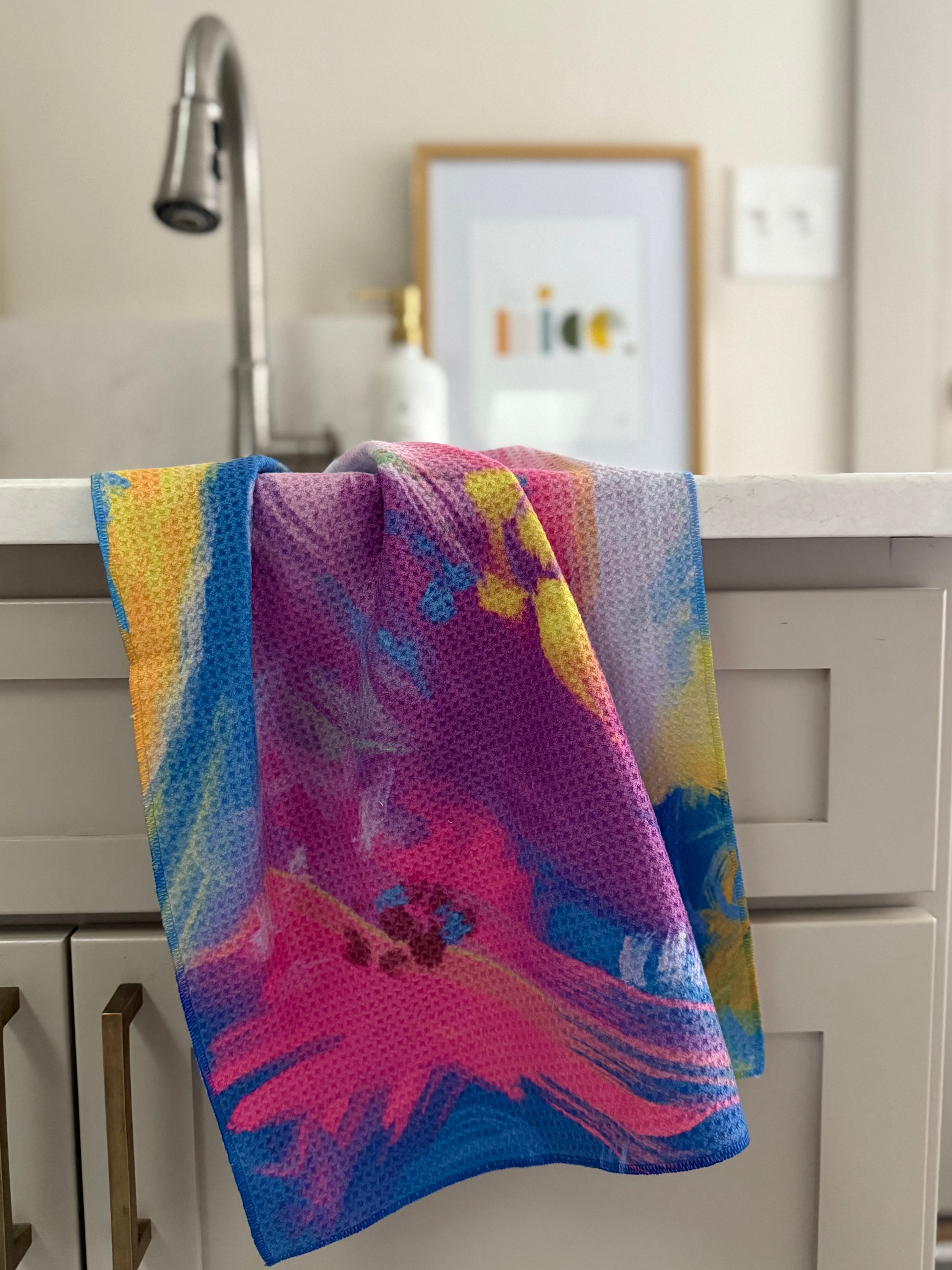 Colorful abstract floral quick-dry towel hanging by laundry room sink. Bloom design is based on Isaiah 35:2.