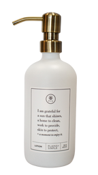 White glass I Am Grateful Lotion Gratitude Bottle with gold pump.