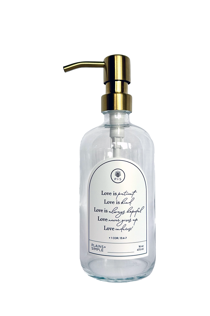 Clear glass Love Is... multipurpose Gratitude Bottle with gold pump.