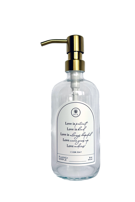 Clear glass Love Is... multipurpose Gratitude Bottle with gold pump.
