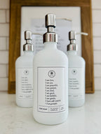 White glass Fruits of the Spirit dish soap Gratitude Bottle with silver pump sitting with the matching hand soap and lotion bottles on a kitchen counter.