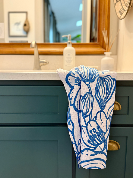 Blue & white floral pattern Presence quick-dry hand towel by bathroom sink.