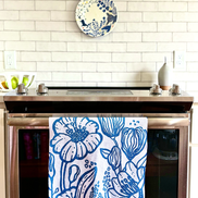 Blue & white, floral patterned, Presence quick dry towel hanging on a stove brightening up a kitchen.