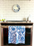 Blue & white, floral patterned, Presence quick dry towel hanging on a stove brightening up a kitchen.