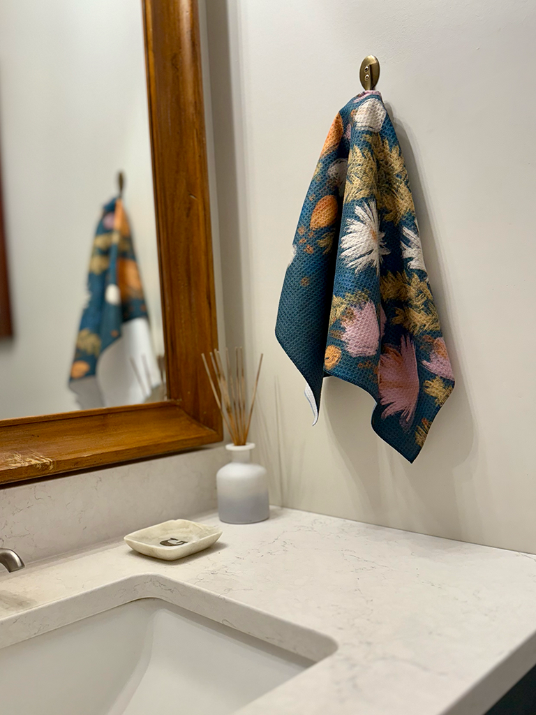 Wildflower multipurpose hand towel hanging in bathroom near the sink.