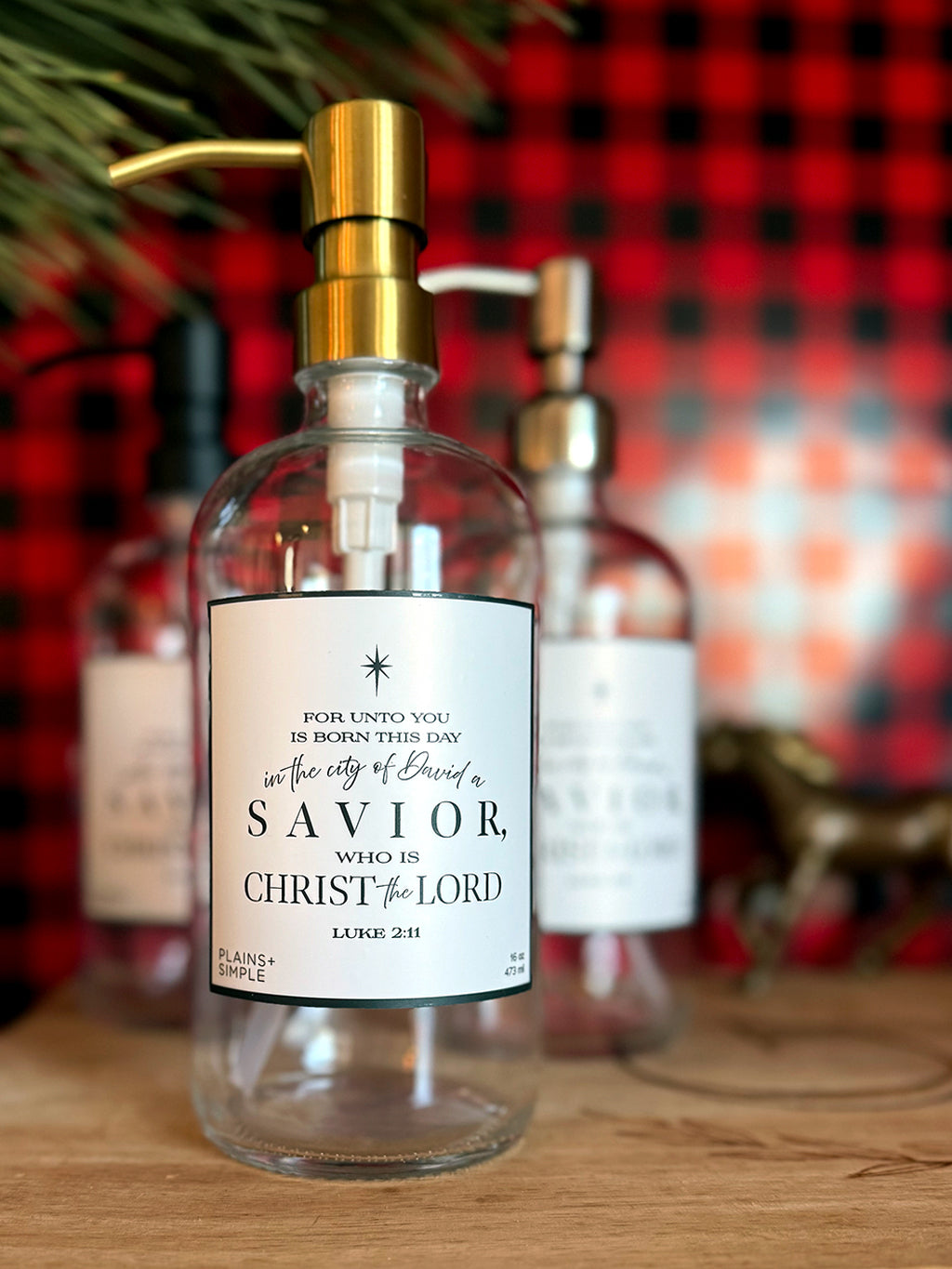 Reusable glass Christmas Gratitude Soap dispenser amongst Christmas decorations 