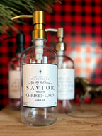 Reusable glass Christmas Gratitude Soap dispenser amongst Christmas decorations 